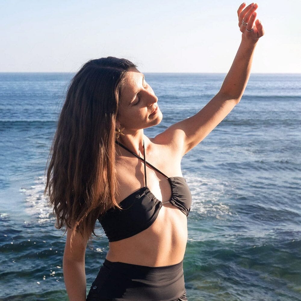 Swimwear Tops - Model leaning against a tree in a swimsuit