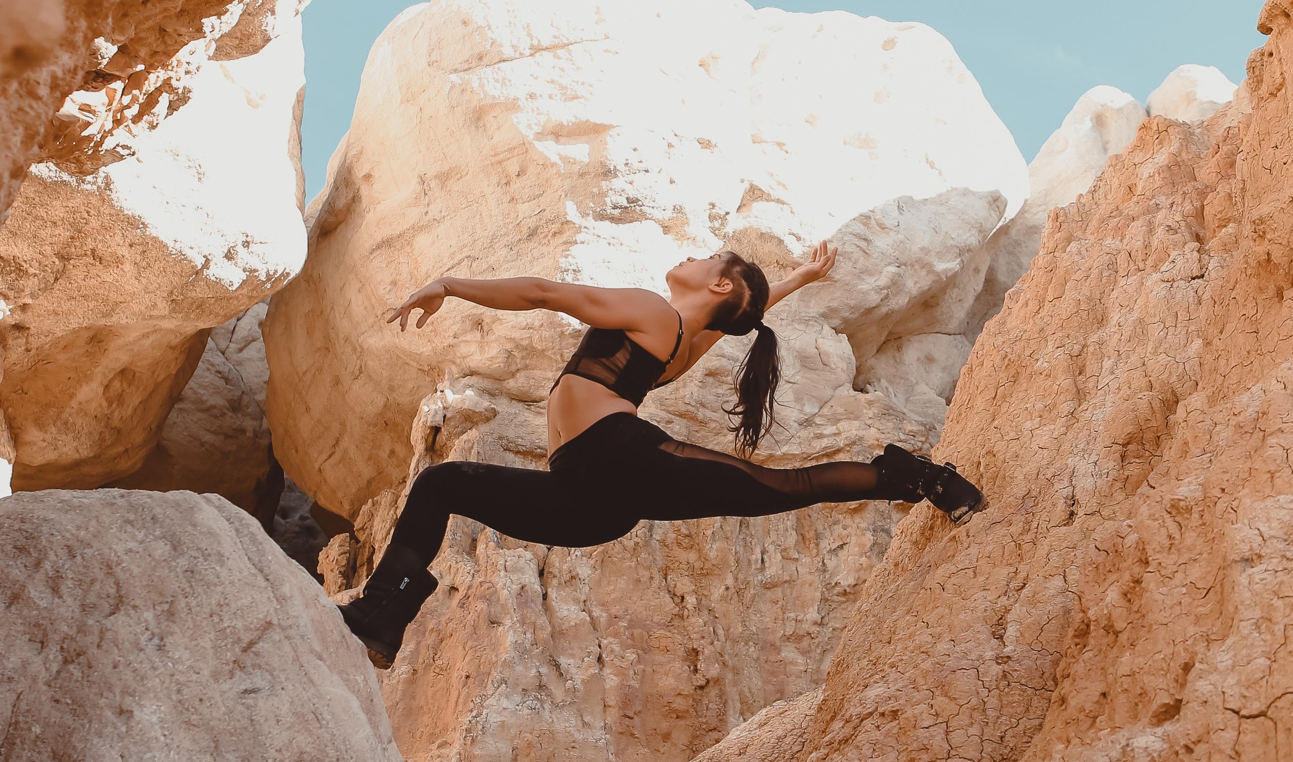 Model wearing Lucina Mesh Legging performing a yoga pose against large rock formations