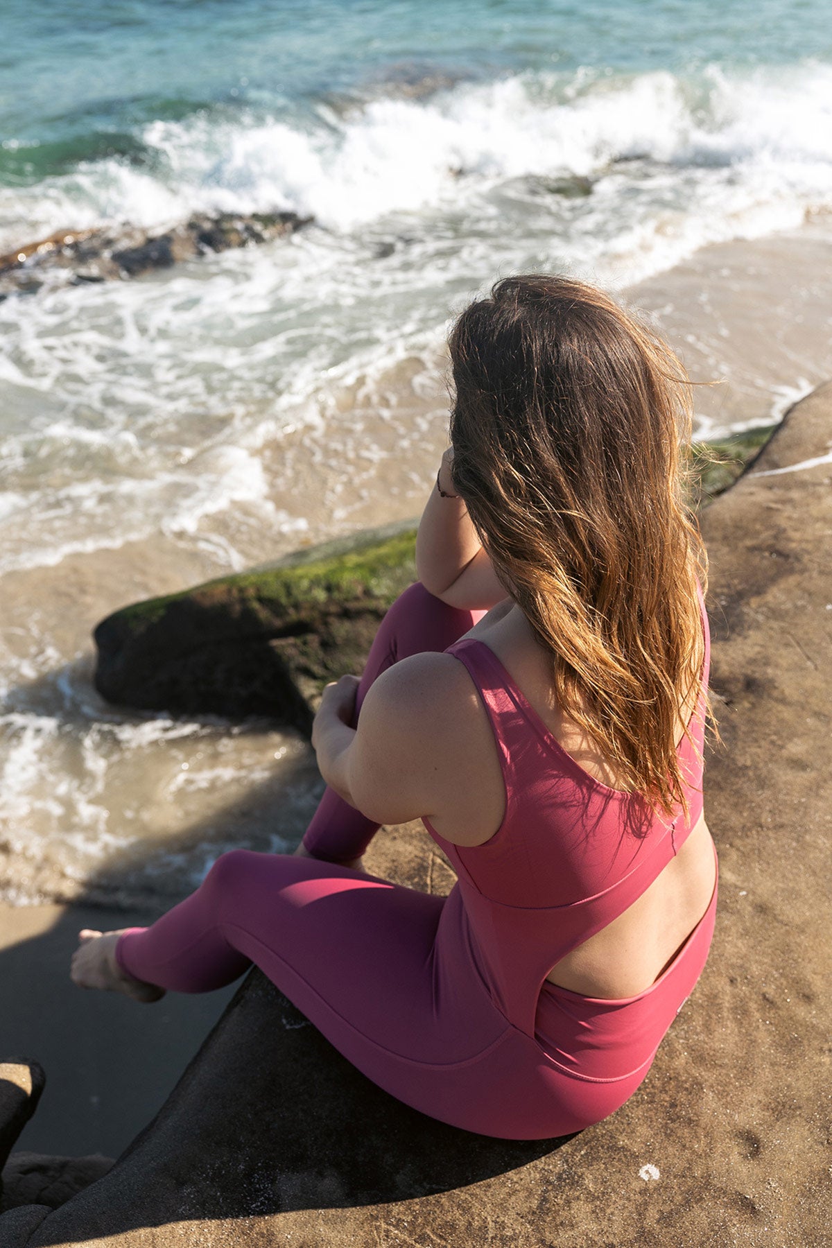 Model on the beach wearing Stevie Bodysuit in Blush color